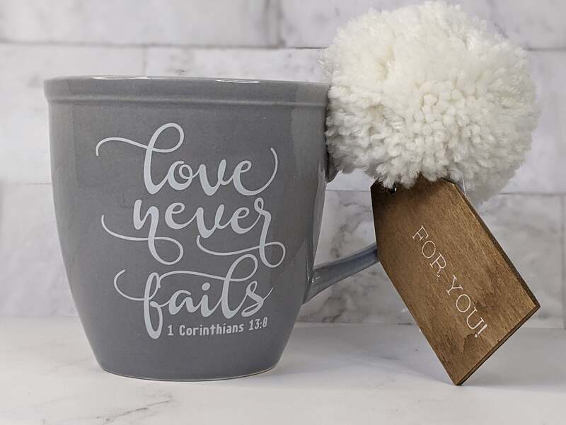 Love Never Fails Mug with Pom and Tag